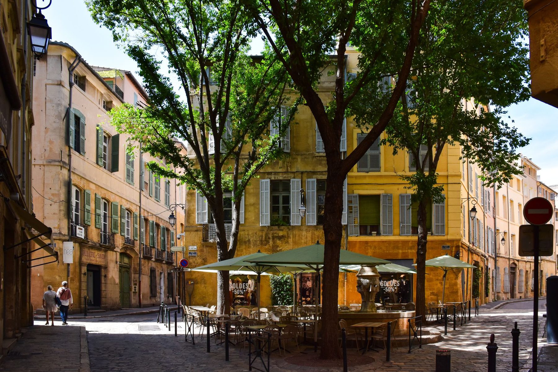 Terrasse de café sous les platanes, sur une place de village